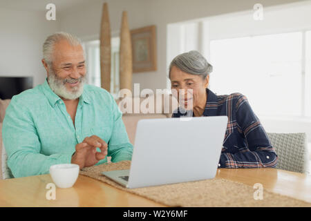 Couple using laptop on table inside a room Stock Photo