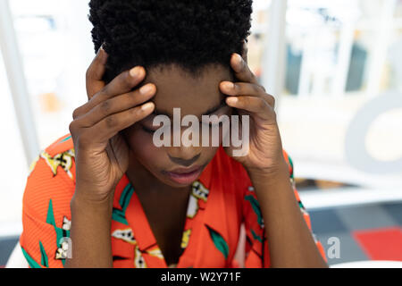 Stressed female graphic designer sitting at desk Stock Photo
