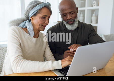Couple using white laptop on a table. Stock Photo