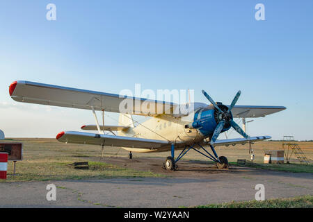 An-2, a small propeller sports aircraft at a sports airfield. Termination aircraft for pilot training and parachute jumping on the grass near the runw Stock Photo