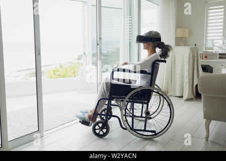 Woman on wheelchair using virtual reality headset Stock Photo