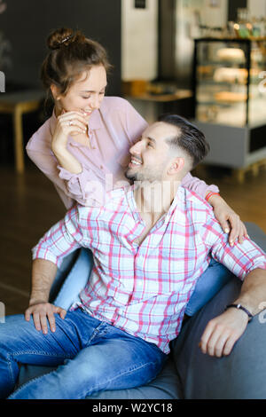 Happy smiling husband sitting with nice wife at home. Concept of spending time together and relationship. Stock Photo