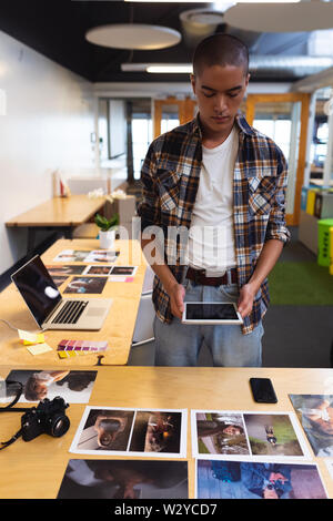 Male graphic designer using digital tablet at desk Stock Photo