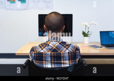 Disabled male executive working on computer at desk in office Stock Photo