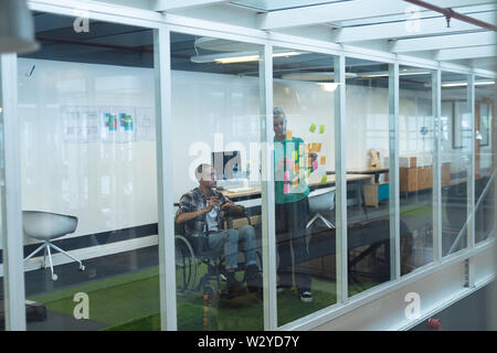 Male and female executives discussing over sticky notes in office Stock Photo