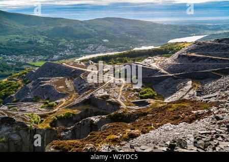 View west from a high bench at Dinorwic Quarry, with Llyn Padarn and Llanberis visible in the distance. Stock Photo