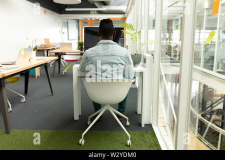 Male graphic designer working on computer at desk in office Stock Photo