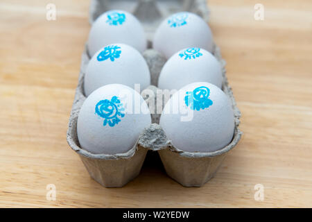 Cacklebean White free range hens eggs with a blue stamp in an eggbox with shallow depth of field Stock Photo