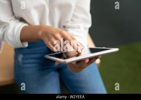 Female graphic designer using digital tablet at desk Stock Photo