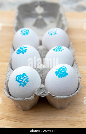 Cacklebean White free range hens eggs with a blue stamp in an eggbox with shallow depth of field Stock Photo
