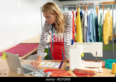Female fashion designer using laptop at desk Stock Photo