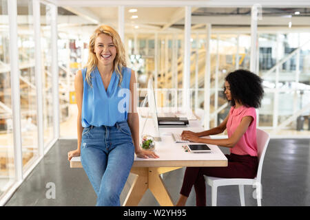 Female executive sitting at desk in office Stock Photo