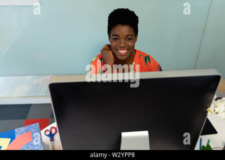 Female graphic designer working on computer at desk in office Stock Photo