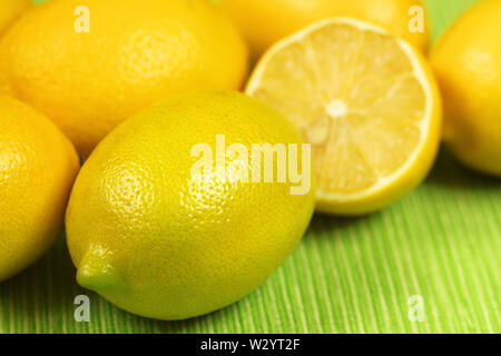 Closeup of whole fresh juicy yellow lemons on green background Stock Photo