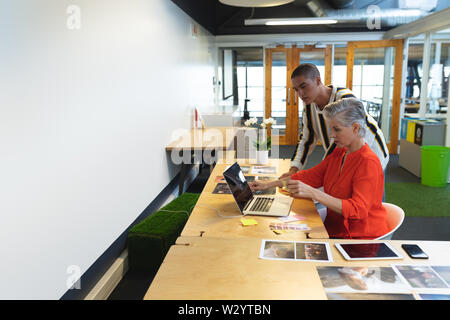 Male and female graphic designers working together at desk Stock Photo