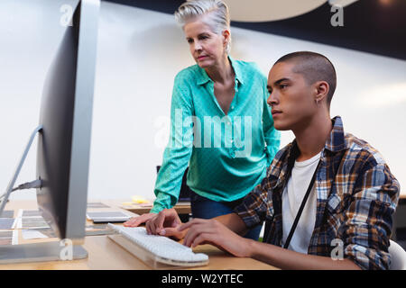 Male and female graphic designers working together on computer at desk Stock Photo