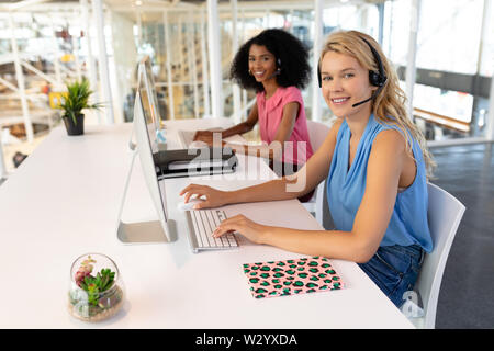 Female customer service executives working at desk in office Stock Photo