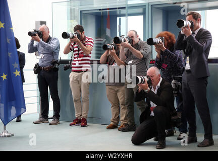 Berlin, Germany. 11th July, 2019. Journalists at the Federal Chancellery follow the arrival of the Federal Chancellor and her guest from Denmark at the press conference. Credit: Wolfgang Kumm/dpa/Alamy Live News Stock Photo