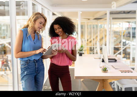 Female executives discussing over digital tablet in office Stock Photo