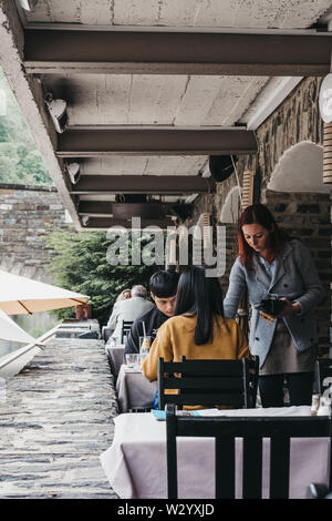 Vianden, Luxembourg - May 18, 2019: People paying for a meal at the outdoor tables of a restaurant in Vianden, a town in Luxembourgs Ardennes region k Stock Photo