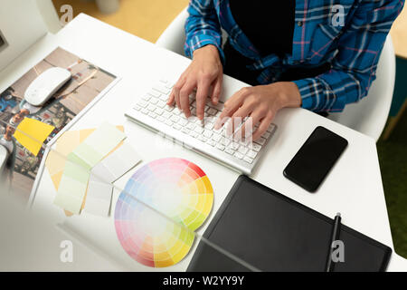 Female graphic designer working on computer at desk Stock Photo