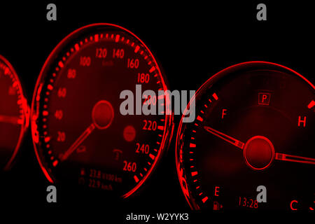 Close up shot of red speedometer in a car. Car dashboard. Dashboard details with indication lamps.Car instrument panel. Dashboard with speedometer, ta Stock Photo