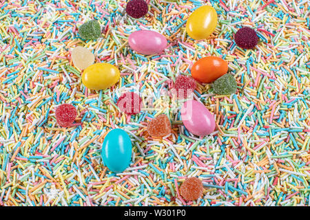 variety of candies on a wooden background with space for text. Colorful sugar sprinkles. Easter Stock Photo