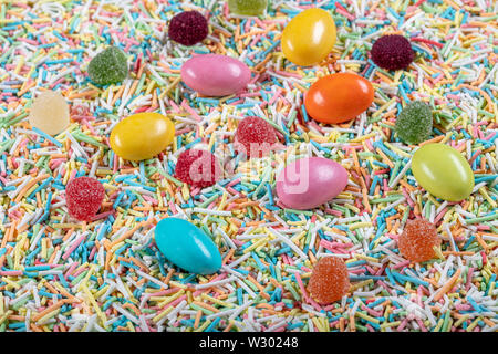 variety of candies on a wooden background with space for text. Colorful sugar sprinkles. Easter Stock Photo