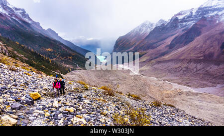 Seniors hiking the moraines of the Victoria Glacier from the Plain of Six Glaciers Tea house to the Six Glaciers at Lake Louise, Banff National Park Stock Photo