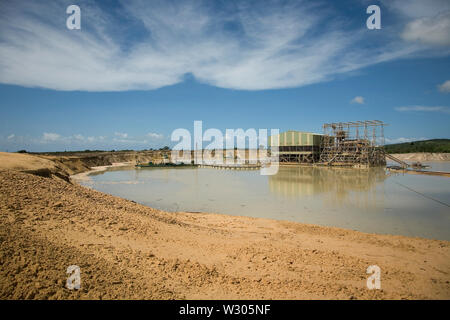 Managing & transporting of titanium mineral sands at mine site.  Mining by dredging in freshwater pond. Dredges pump sand into wet concentrator plant. Stock Photo