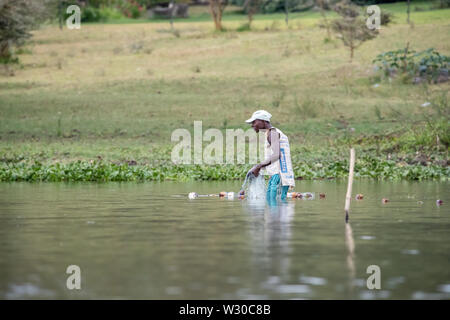 Lake Naivasha, Kenya - 19th February 2019: Local fisherman casts his nets in the shallow waters of Lake Naivasha, Kenya. Stock Photo