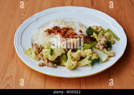 stir fried mixed vegetable with pork and spicy shrimp paste on rice Stock Photo