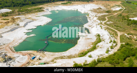 Aerial view of a blue-green quarry pond for quartz sand in Germany with the suction dredger and the conveyor belt for the sand Stock Photo