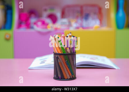 Pen, pencil and accessory in black basket isolated on blured background .Colored pencils in a pencil case on blured background Stock Photo