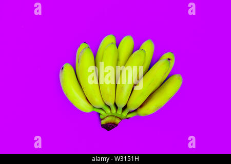 Bunch of bananas on magenta backdrop top view. Tropical and exotic fruit flat lay on pink background. Healthy vegan and vegetarian diet. Summertime de Stock Photo