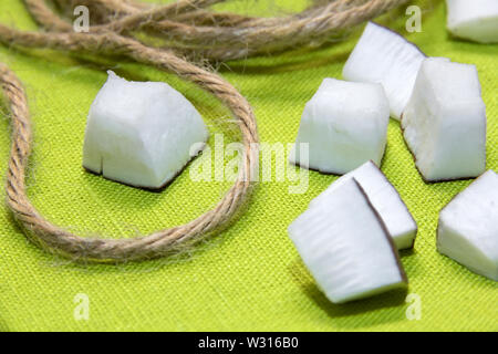 Pieces of coconut and jute rope on a green background Stock Photo