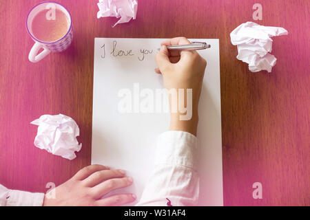 Woman writing a romantic letter with the text i love you , space for text beauty Stock Photo