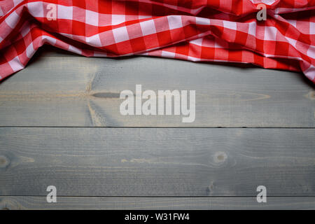 a checked gingham picnic tablecloth on old wooden table top view Stock Photo