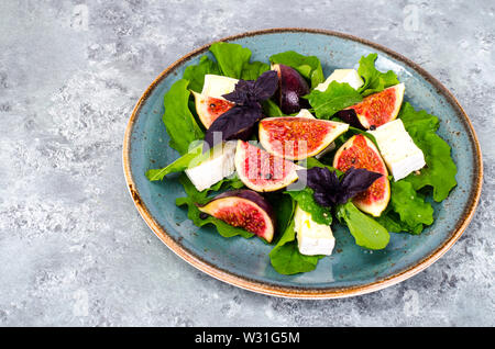 Delicatessen salad with figs and cheese on gray blue background Stock Photo