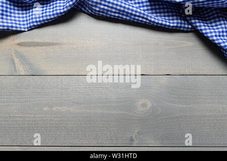 a checked gingham picnic tablecloth on old wooden table top view Stock Photo