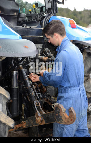 GREYMOUTH, NEW ZEALAND; DECEMBER 15, 2018: An unnamed mechanic works on the back of a tractor. Stock Photo