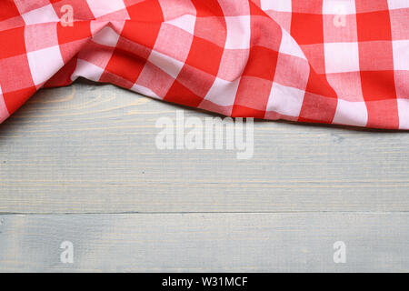 a checked gingham picnic tablecloth on old wooden table top view Stock Photo