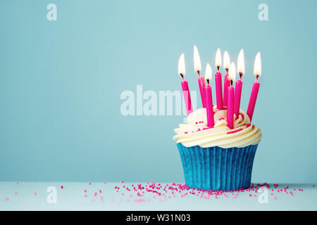 Birthday cupcake with pink candles on a blue background Stock Photo