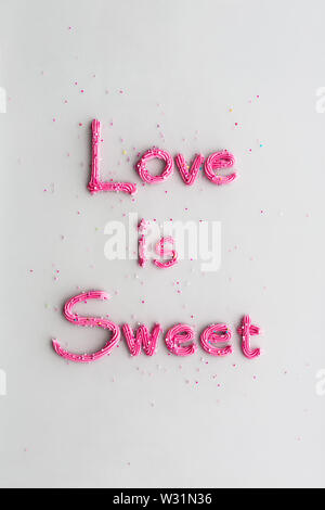 Love is sweet written in buttercream frosting Stock Photo