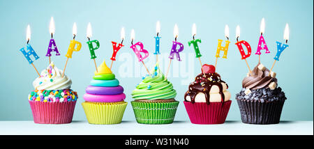 Colorful cupcakes with candles spelling Happy Birthday Stock Photo