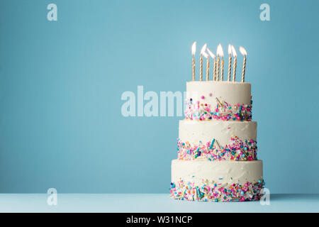 Birthday cake with three tiers and colorful sprinkles Stock Photo