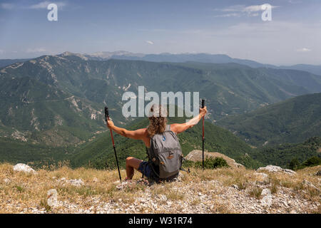 Subiaco RM, Italy - 07 July 2019: woman hiker admires the landscape on the horizon, from the top of the mountain. Stock Photo