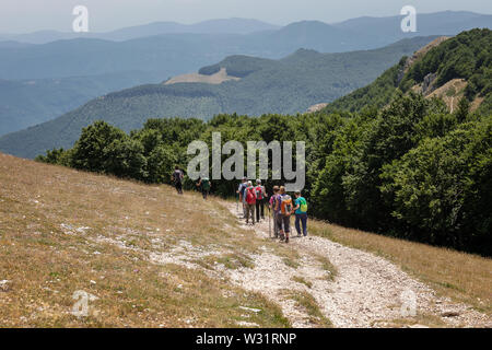 Subiaco RM, Italy - 07 July 2019: Group of hikers on the mountain path, descend from the top of Mount Autore. The Lepini Mountains of the central Apen Stock Photo