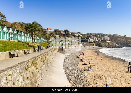 LANGLAND BAY, GOWER, WALES - FEBRUARY 2019: Person walking along the promenade in sunshine in Langland Bay on the Gower penninsula in Wales. Stock Photo