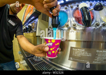 A worker fills a Slurpee in a 7-Eleven store in New York on Thursday, July 11, 2019 (7-11, get it?),the self-proclaimed holiday Free Slurpee Day! The popular icy, slushy, syrupy drinks are available in regular and diet flavors, in combinations, and the stores have stocked up with extra barrels of syrup to meet the expected demand. According to the meticulous figures kept by 7-Eleven they sell an average of 14 million Slurpees a month and over 150 million Slurpees a year.  (© Richard B. Levine) Stock Photo
